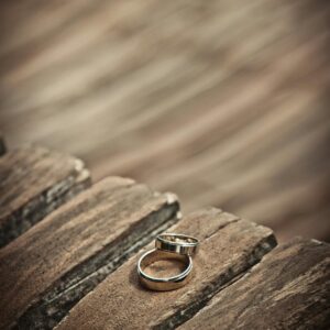 Close-up of elegant silver wedding rings on a rustic wooden surface, symbolizing love and unity.